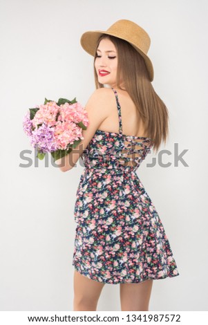 blonde in a straw hat and dress with a bouquet of flowers on a white background