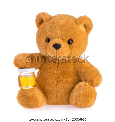 Teddy bear holding honey pot isolated white background
