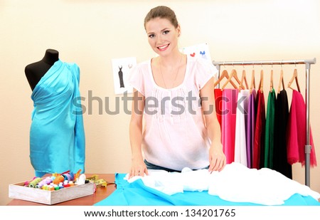 beautiful young dressmaker in workroom