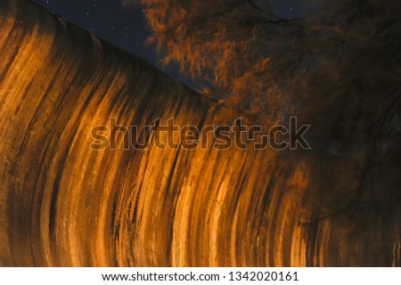 Light painted abstract night photo of Wave Rock, Hyden Western Australia.
Creative surreal wave like capture, with the branches of a tree imitating spray coming from the wave.
Fantasy background.
