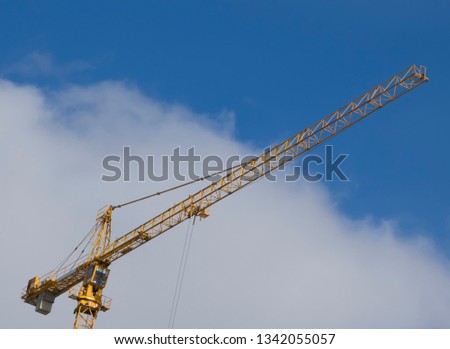 View for Working yellow construction crane against blue sky 