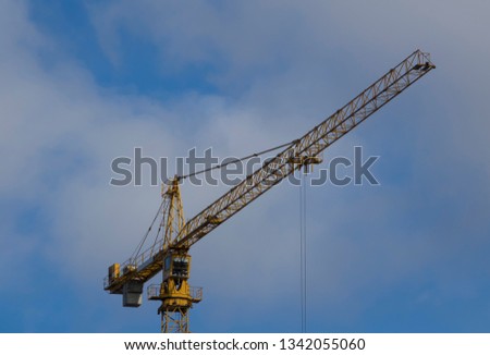 View for Working yellow construction crane against blue sky 