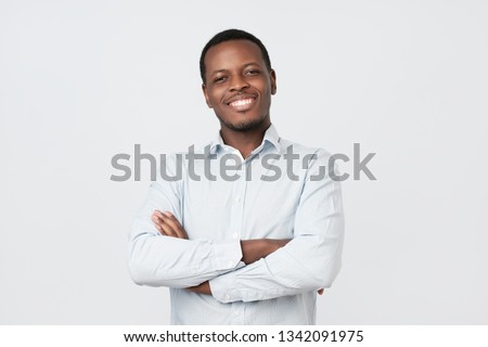 Laughing handsome young african man in shirt smiling confident. Positive facial emotion