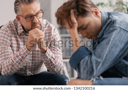 Professional counselor and troubled teenager during therapy meeting Royalty-Free Stock Photo #1342100216