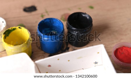jars of gouache paint watercolor on the table creative mess, children's creativity, art school