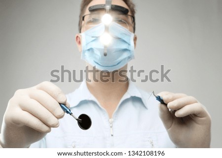 dentist with mirror and hook - closeup picture over white background