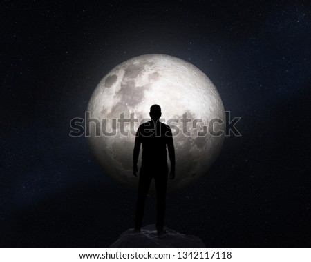 Silhouette of a man on background of the Moon. Elements of this image furnished by NASA.