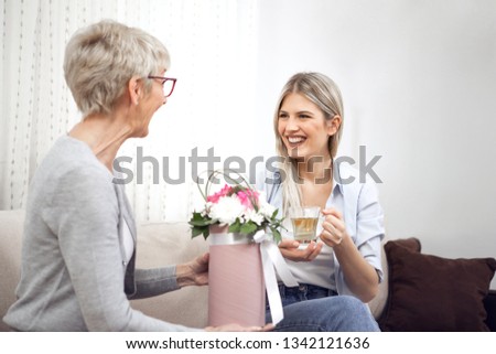 Middle-aged lady got beautiful flowers from her daughter.