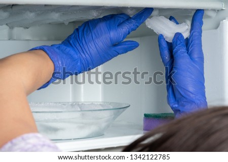 The girl washes the freezer. Cleaning the refrigerator. Royalty-Free Stock Photo #1342122785