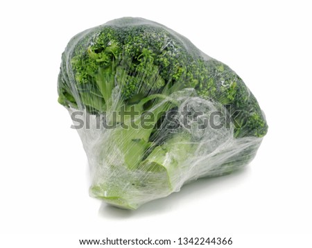 Broccoli wrapped in plastic foil isolated on white background Royalty-Free Stock Photo #1342244366