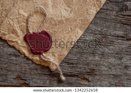 old blank parchment paper on wooden background. Close up of wax seal.