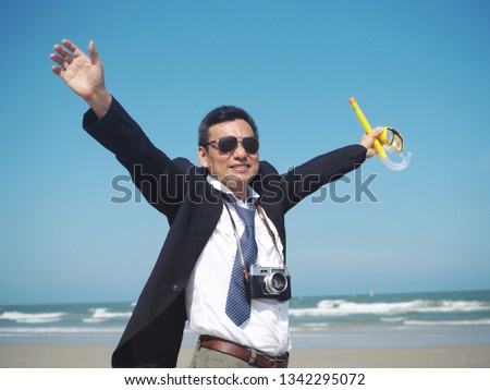 Happy Senior business man standing on the tropical beach,traveler summer concept.