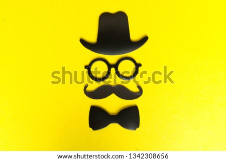 Booth made of cardboard props mustache, hat, glasses isolated on yellow background. Birthday and Party Set