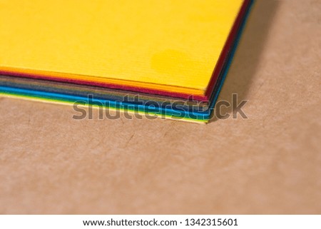 Stack of colorful paper. Blurring background. The corners of sheets of paper close-up. Back to school. Bright natural background.