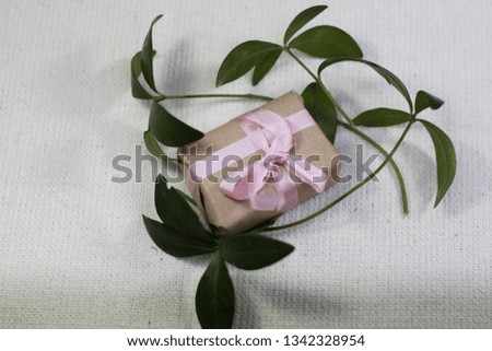 small present wrapped in paper and bowed silk ribbon, dry roses, copy space