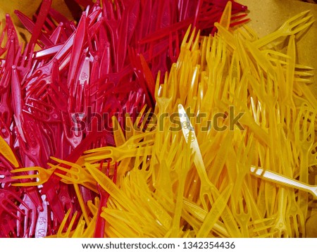 Bunch of yellow and red plastic forks