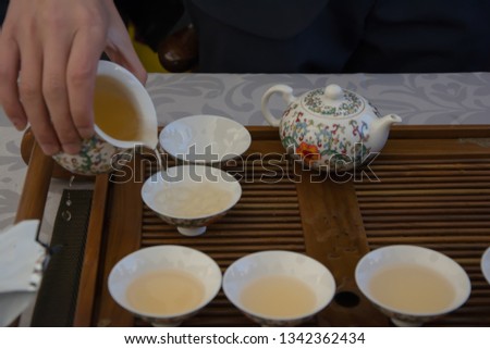 Hands preparing tea for six people, customs of courtesy in the world
