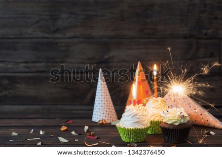 birthday cupcakes with candles on old dark  wooden background