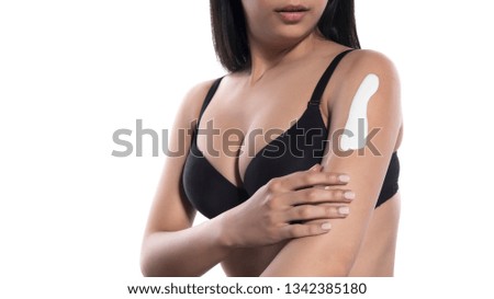 smiling young woman apply lotion on her body. isolated
