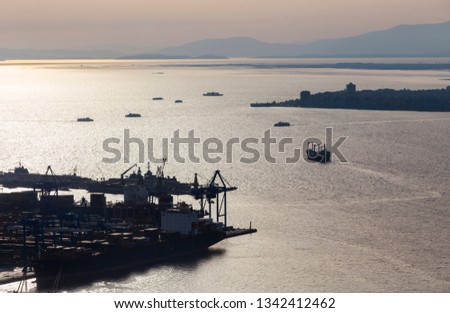Ship is leaving the harbor. Izmir bay view. Harbor silhouette at the sunset. Aegean sea. 