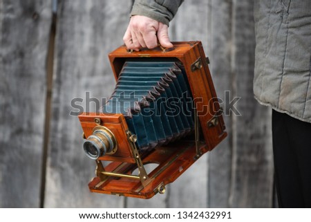 Photographer holds old large format studio camera, 5x7 inches. Concept - photography of the 1930s-1950s.