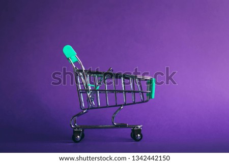 Empty shopping basket on violet background