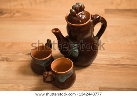 Ceramic teapot and cups on wooden