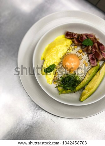 Egg scramble with rice, yolk, white fish fillet, corn and avocado. High resolution picture perfect for cooking book, receipt book or food magazine.