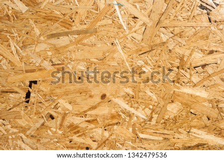 OSB boards are made of brown wood chips sanded into a wooden background. Top view of OSB wood veneer background, tight, seamless surfaces. OSB panel texture