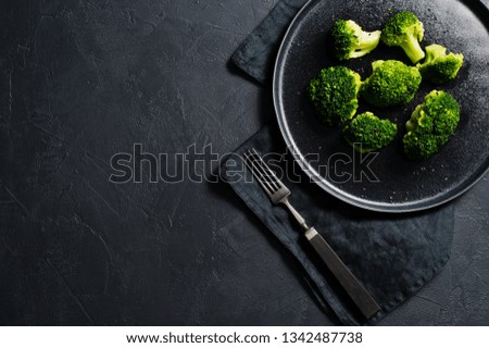 Broccoli on a black plate. Black background, top view, space for text