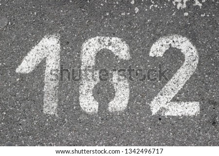 Parking lot asphalt stencil number 162 street sidewalk