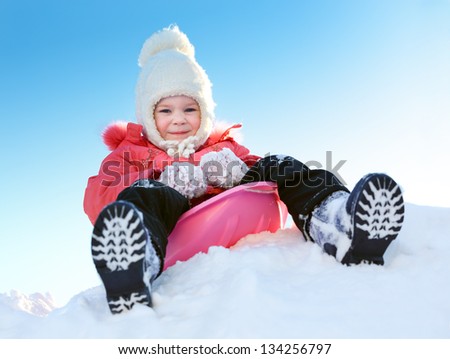 Girl with sleds on the hill against the blue sky