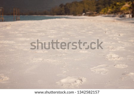 Soft waves of ocean at tropical long white sand beach with many footprint on the beautiful island of Koh Rong, Cambodia