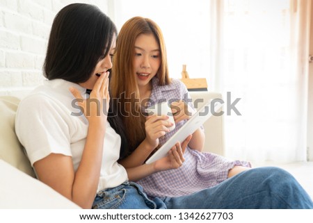 Young asian happy woman .women shopping online .Young girl thinks about purchasing through the internet sitting on the sofa.woman holding credit card and using laptop computer. Online shopping concept