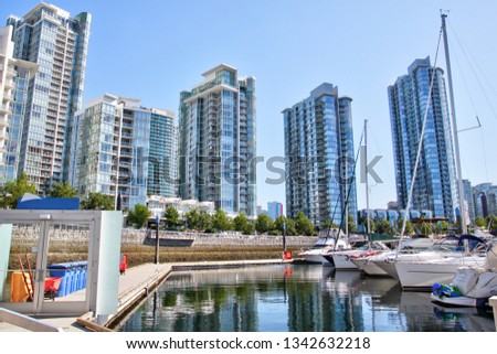 Yachts at the waterfront on False Creek surrounded by highrise condos at Yaletown, formerly a warehouse district in Vancouver but now a chic and densely populated neighborhood in the city.