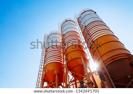 Cement silos of Cement batching plant factory against afternoon sun with clear blue sky Royalty-Free Stock Photo #1342691705