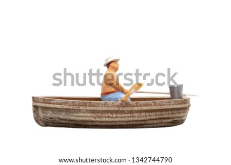 Miniature people sit in a boat on white background with clipping path
