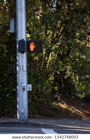 Red hand sign  saying don't walk at an intersection for pedestrians