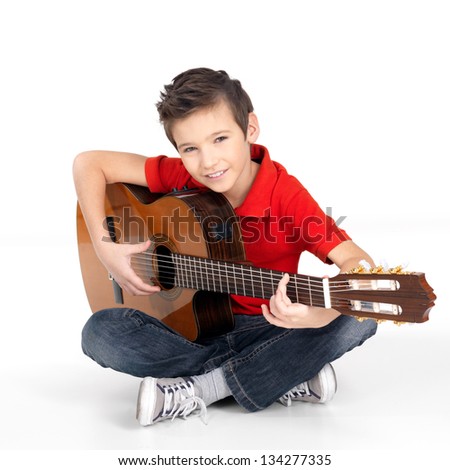 Handsome happy  boy is playing on acoustic guitar - isolated on white background
