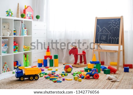 Children's playroom with plastic colorful educational blocks toys. Games floor for preschoolers kindergarten. interior children's room. Free space. background mock up chalkboard Royalty-Free Stock Photo #1342776056