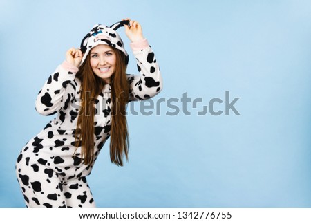 Happy teenage girl in funny nightclothes, pajamas cartoon style smiling, positive face expression, studio shot on blue.