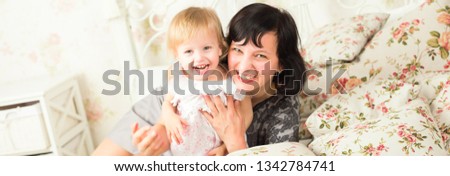 Merry Christmas and Happy Holidays. Happy family: 2 mothers and daughter sitting at cozy room near Christmas tree with gifts. Happy people concept