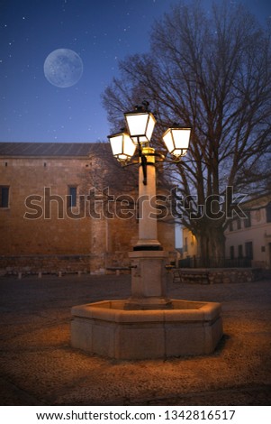 Dark blue sky with stars and  lantern on the square. Winter. Spain. Castle on the hills in Spain. Parador de Alarcón, Cuenca. Júcar River. 