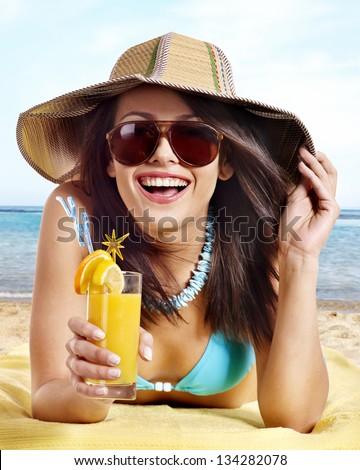 Woman in bikini drinking alcohol cocktail through a straw.