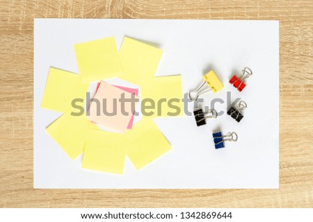 colorful stickers on a white A4 sheet on a wooden background