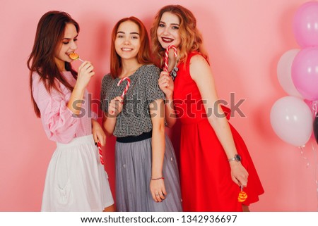 three young and stylish girls in a studio with colored balls