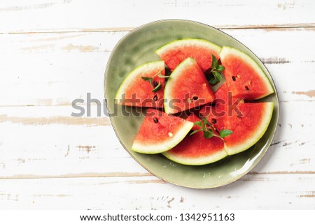 Sliced watermelon in big green plate and white background