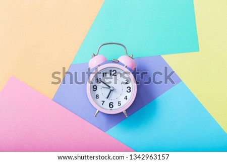 alarm clock on pastel paper background