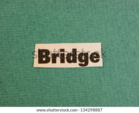 word bridge cut from newspaper on green background