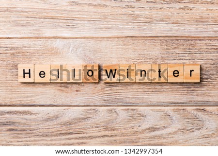 hello winter word written on wood block. hello winter text on wooden table for your desing, concept.